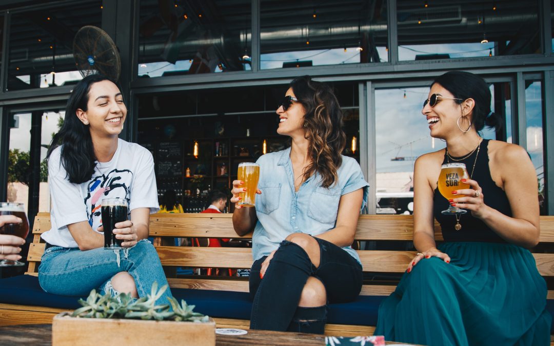 Donne che bevono una bevanda sedute su una panchina